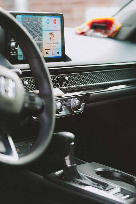 a car dashboard with a cell phone in the center
